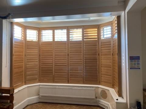 Wooden plantation shutters fitted in a bay window